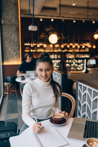 Junge Dame, die im Café im Internet surft