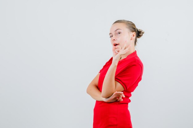 Junge Dame, die ok Geste im roten T-Shirt zeigt und zuversichtlich schaut