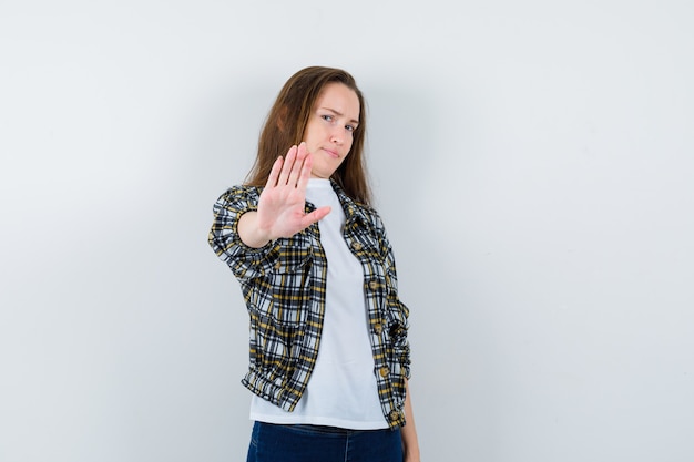 Kostenloses Foto junge dame, die stoppgeste in t-shirt, jacke zeigt und gelangweilt, vorderansicht schaut.