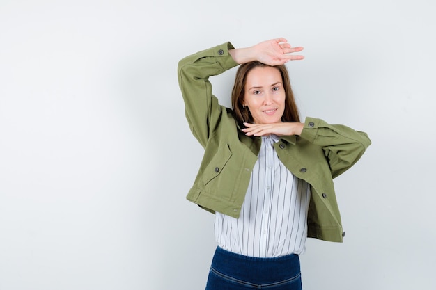 Junge Dame, die traditionelle Tanzgeste in Bluse, Jacke zeigt und zart aussieht.