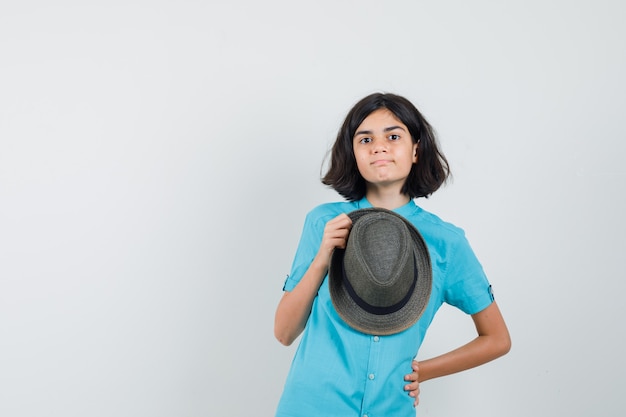 Junge Dame im blauen Hemd, das Hut hält