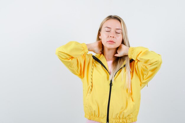 Junge Dame im T-Shirt, Jacke, die Hände am Hals hält und erschöpft aussieht