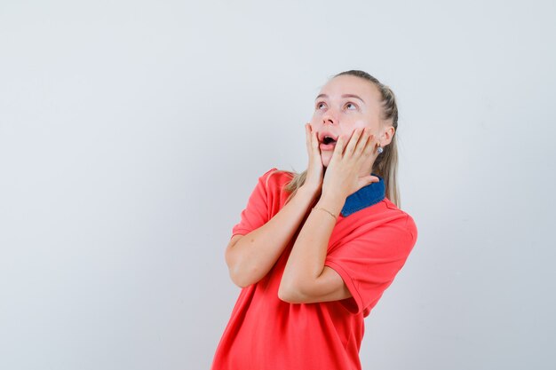 Junge Dame im T-Shirt schaut auf und sieht überrascht aus