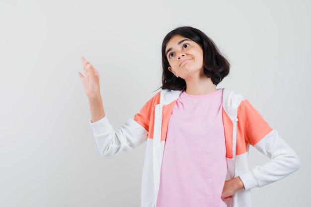 Junge Dame in Jacke, rosa Hemd, das ok Geste zeigt und erfreut aussieht