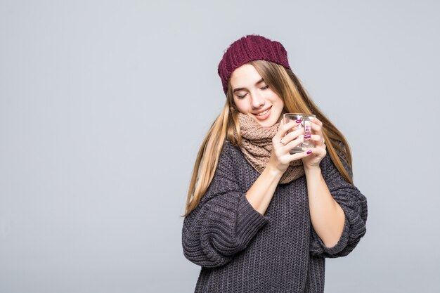 Junge Dame mit Grippe und kalten Getränken heißes Getränk Kräutertee, um auf grau gesund zu werden