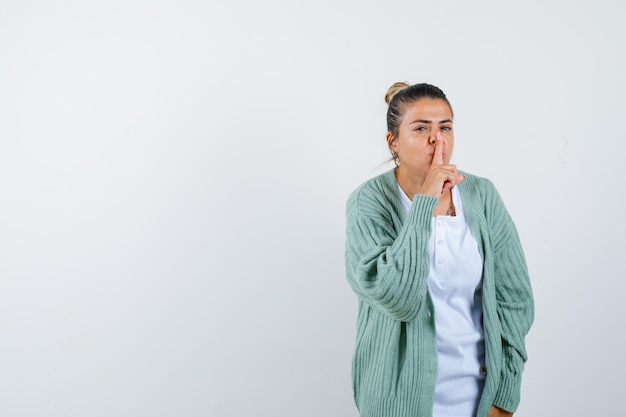 Junge Dame zeigt Stille Geste in T-Shirt, Jacke und sieht selbstbewusst aus looking