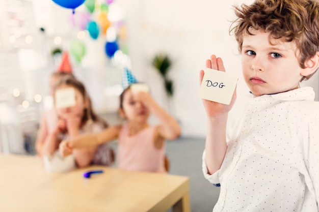 Junge, der Antwort auf Papier zeigt