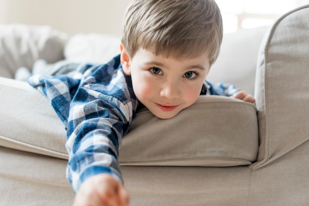 Junge, der auf dem Sofa mittlerer Schuss spielt