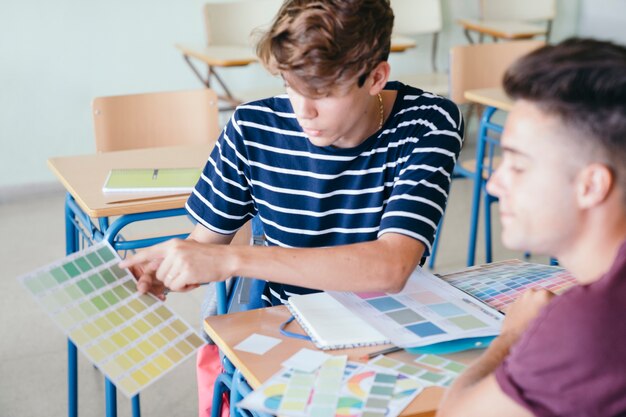 Junge, der die Ausübung seiner Schulkameraden erklärt