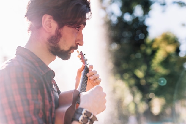 Junge, der die Ukulele spielt