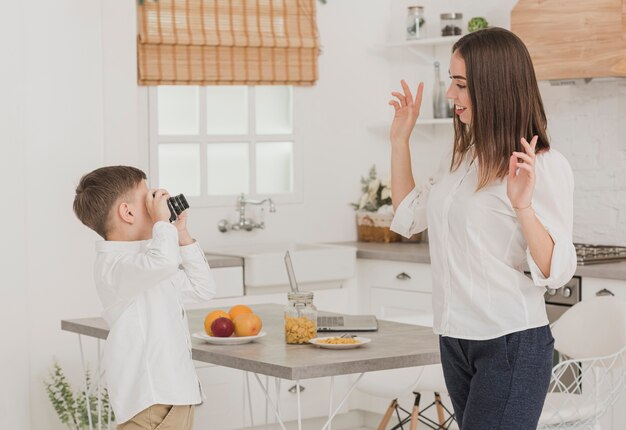 Junge, der ein Foto seiner Mutter macht