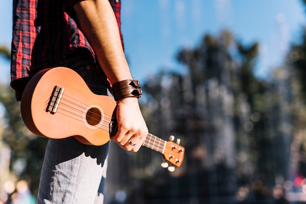 Junge, der ein Ukelele hält