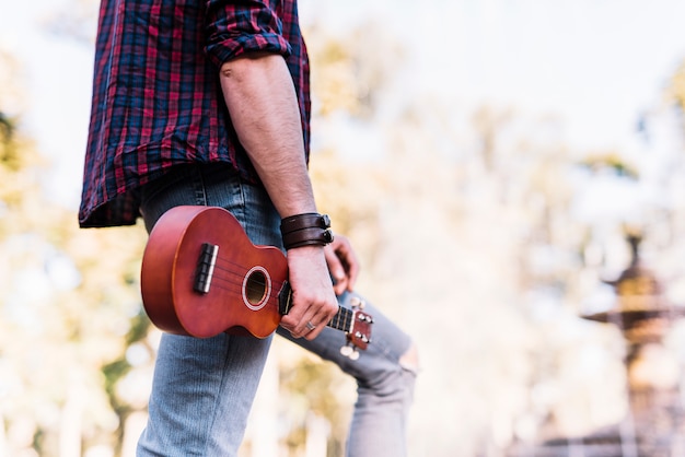 Junge, der ein Ukelele hält