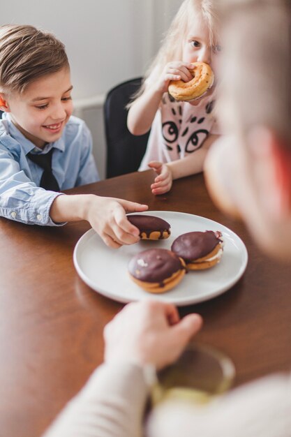 Junge, der einen Krapfen mit Schokolade pflückt