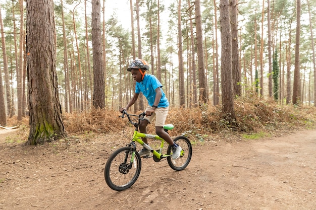 Junge, der Fahrrad im Wald reitet