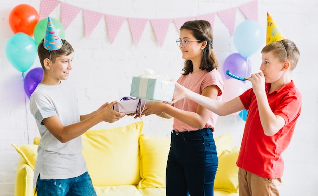 Junge, der Geburtstagsgeschenk von seinen Freunden empfängt