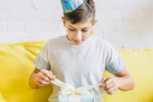 Junge, der Geschenk während seines Geburtstages auspackt