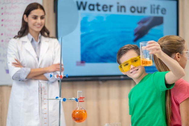 Junge, der Glasstellung mit dem Rücken zum Mädchen zeigt