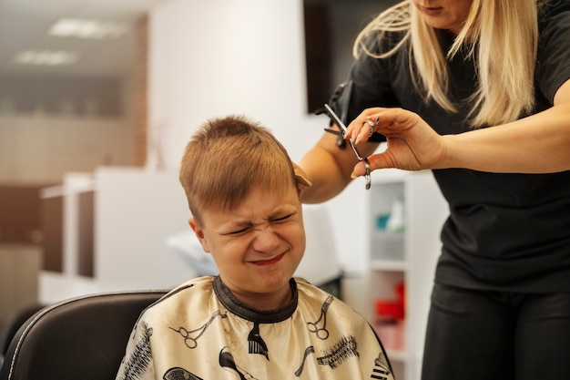 Kostenloses Foto junge, der haarschnitt an der vorderansicht des salons erhält