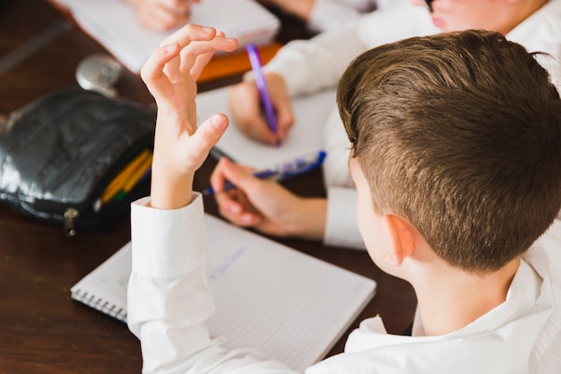 Junge, der Hausarbeit am Schreibtisch tuend denkt