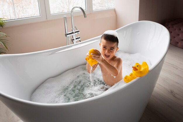 Junge, der im hohen Winkel der Badewanne spielt