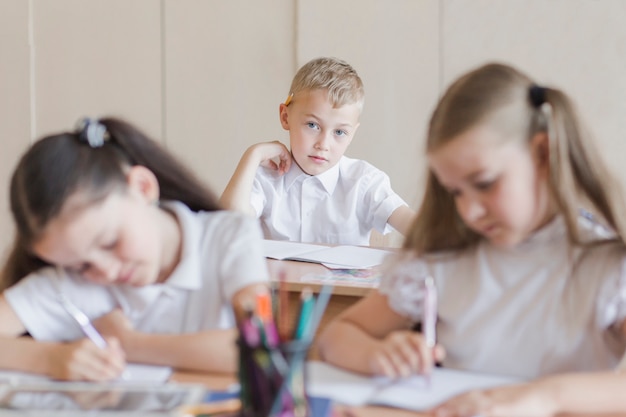 Junge, der Klassenkameraden betrachtet