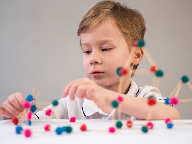 Junge, der mit Chemie-Spiel drinnen spielt