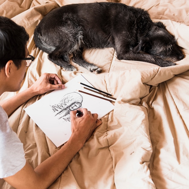 Junge, der mit Holzkohle mit Hund zeichnet