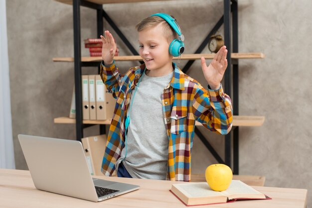 Junge, der Musik auf Laptop hört