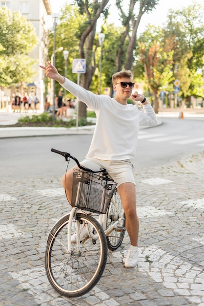 Kostenloses Foto junge, der sein fahrrad draußen nach der pandemie reitet