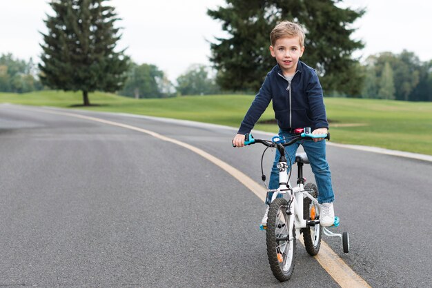 Junge, der sein Fahrrad Vorderansicht reitet