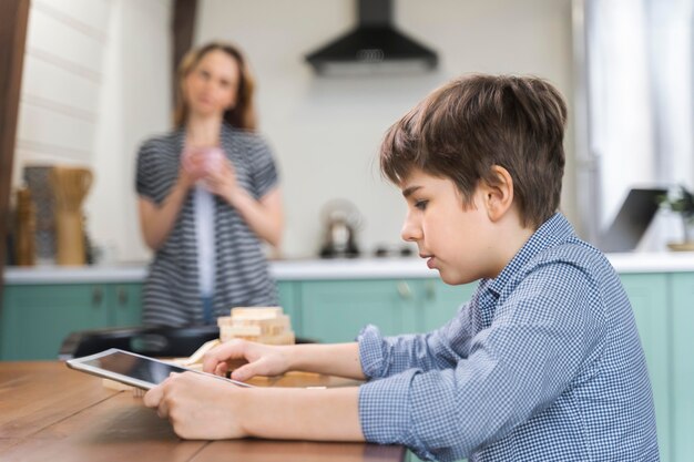 Junge, der seine Hausaufgaben auf Tablette macht