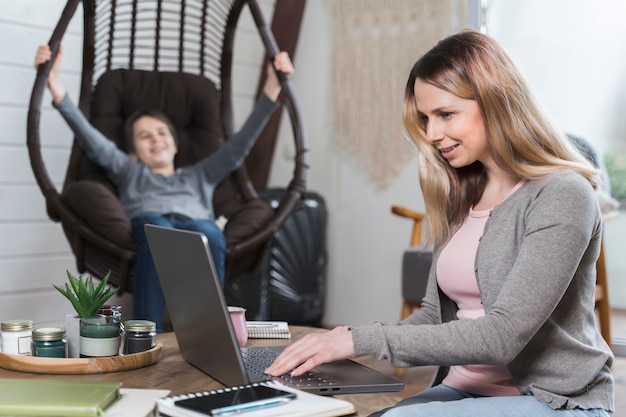 Junge, der sich entspannt, während Mutter von zu Hause aus arbeitet