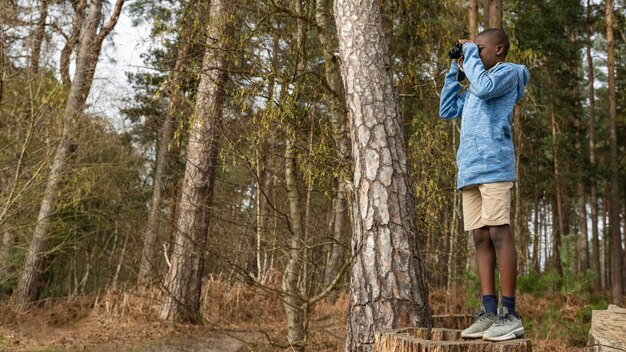 Junge, der Spaß im Wald hat