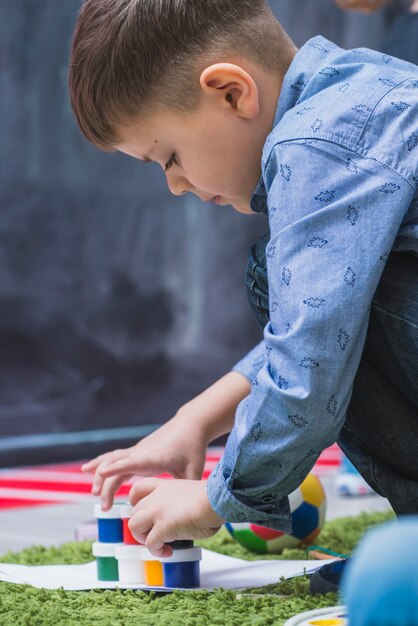 Junge, der Spielwaren auf Boden errichtet