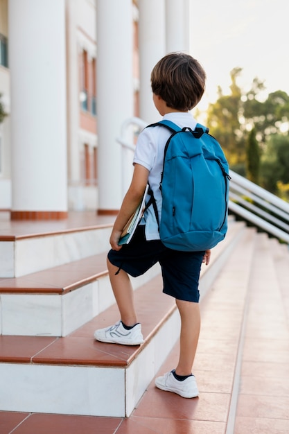 Kostenloses Foto junge, der zurück zur schule kommt