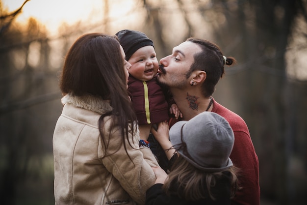 Junge Eltern küssen Baby während posieren