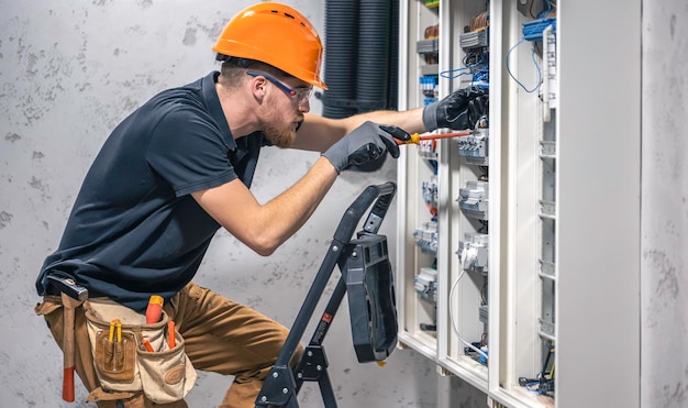 Kostenloses Foto junge erwachsene elektrotechniker-bauingenieur, die geräte in die sicherungskiste schrauben