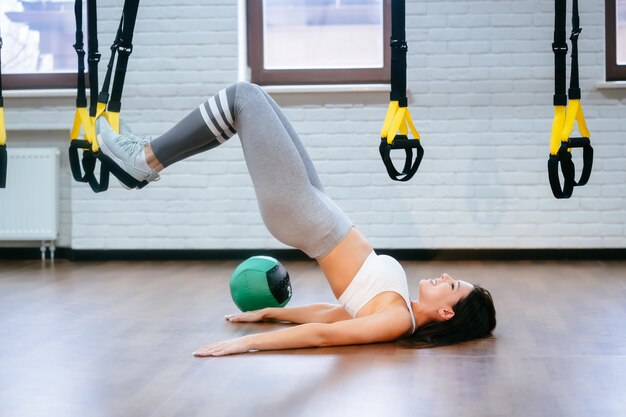 Junge erwachsene Frau, die Übungen im Fitnessstudio macht