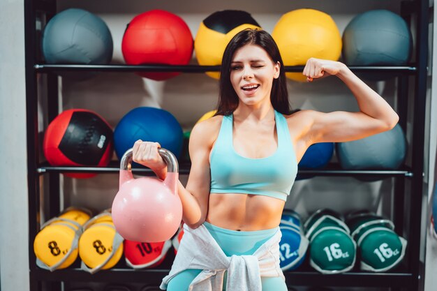 Junge erwachsene Frau, die Kraftübungen im Fitnessstudio tut