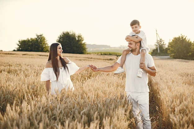 Junge Familie am Weizenfeld an einem sonnigen Tag.