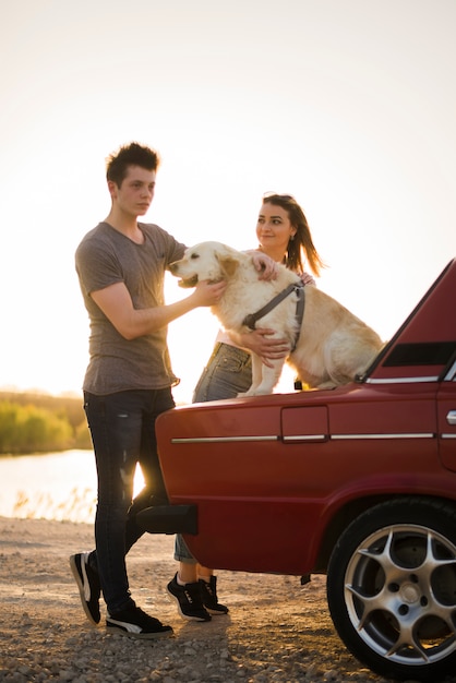 Junge Familie auf einer Autoreise mit ihrem Hund