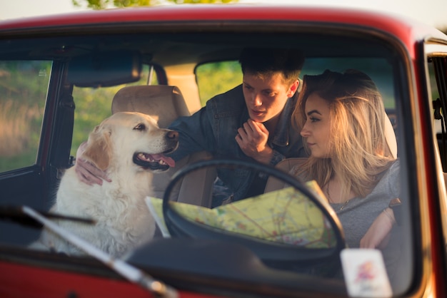 Kostenloses Foto junge familie auf einer autoreise mit ihrem hund