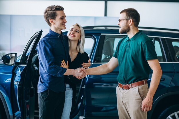 Junge Familie, die ein Auto in einem Autosalon kauft