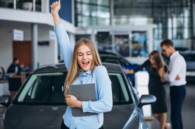 Junge Familie, die ein Auto in einem Autosalon wählt