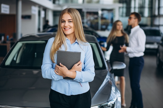 Junge Familie, die ein Auto in einem Autosalon wählt