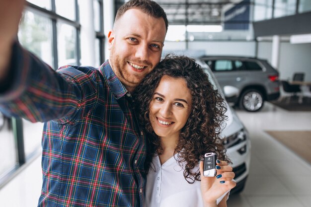 Junge Familie, die selfie in einem Autoshowraum macht