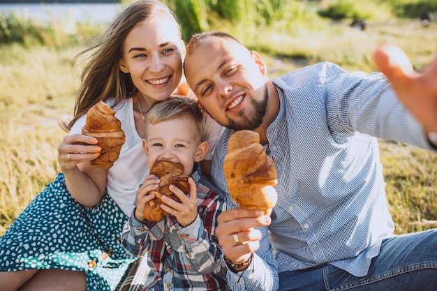 Junge Familie mit dem kleinen Sohn, der Picknick im Park hat