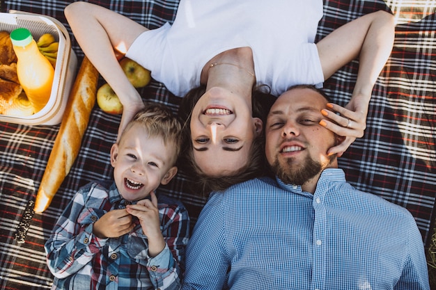 Kostenloses Foto junge familie mit dem kleinen sohn, der picknick im park hat