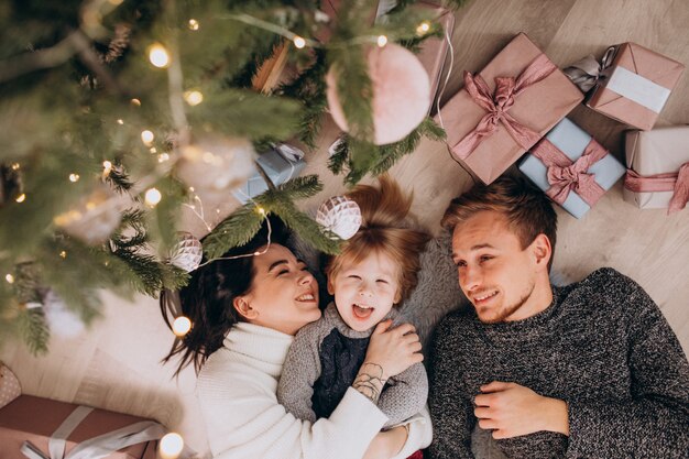 Junge Familie mit kleinem Sohn unter dem Weihnachtsbaum